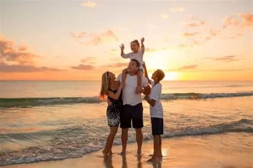 Family together at the beach during sunset